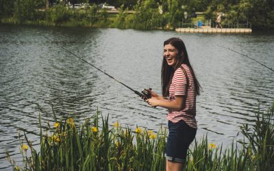 Woman in Red Striped Shirt and Blue Denim Shorts Holding Fishing Rod